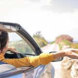 woman in yellow long sleeve driving car