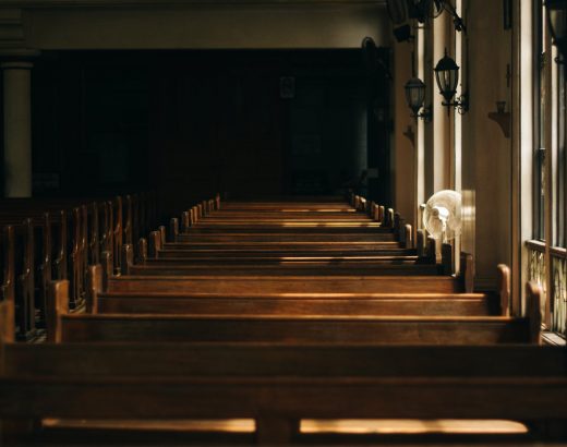 brown wooden church bench near white painted wall
