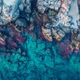 aerial photography of rocks beside body of water
