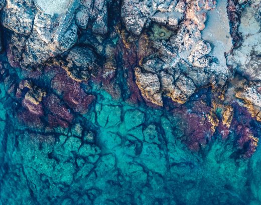aerial photography of rocks beside body of water