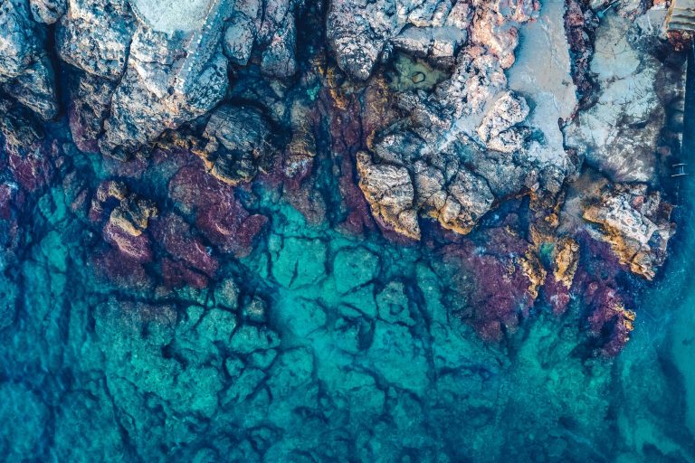 aerial photography of rocks beside body of water