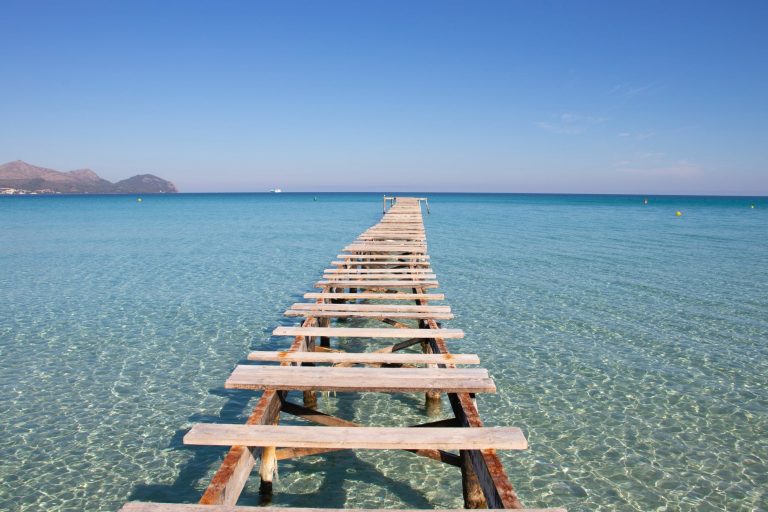 broken wooden dock on sea under blue sky