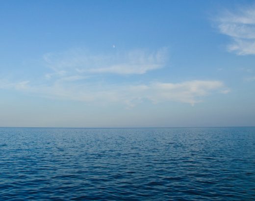 blue body of water under white clouds